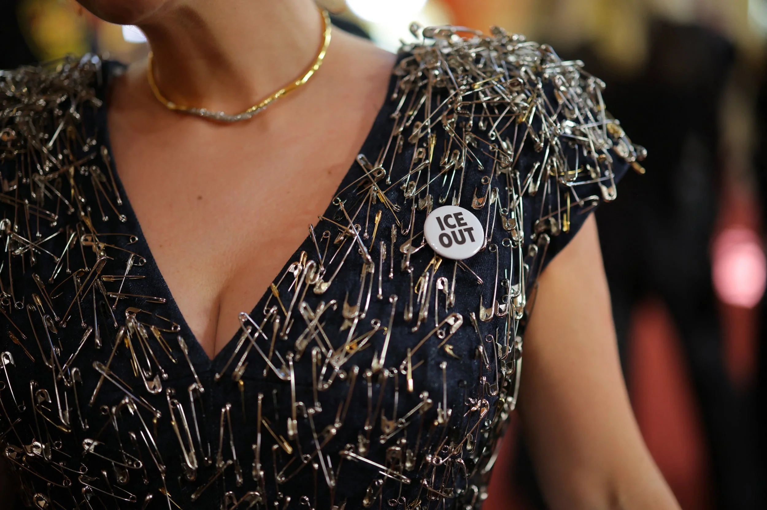 Safety pins and a button reading ICE OUT adorn the dress of Malgosia Turzanska on the red carpet during the Oscars arrivals at the 98th Academy Awards in Hollywood, Los Angeles, California, U.S., March 15, 2026. REUTERS/Carlos Barria