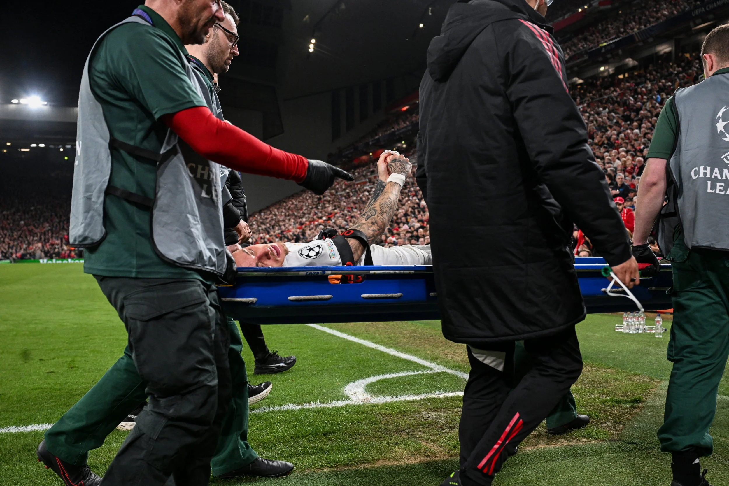 Galatasaray's Dutch forward #77 Noa Lang (C) is evacuated on a stretcher after cutting his thumb during the UEFA Champions League, round of 16 second leg football match between Liverpool and Galatasaray at Anfield in Liverpool, north-west England on March 18, 2026. (Photo by Paul ELLIS / AFP via Getty Images)