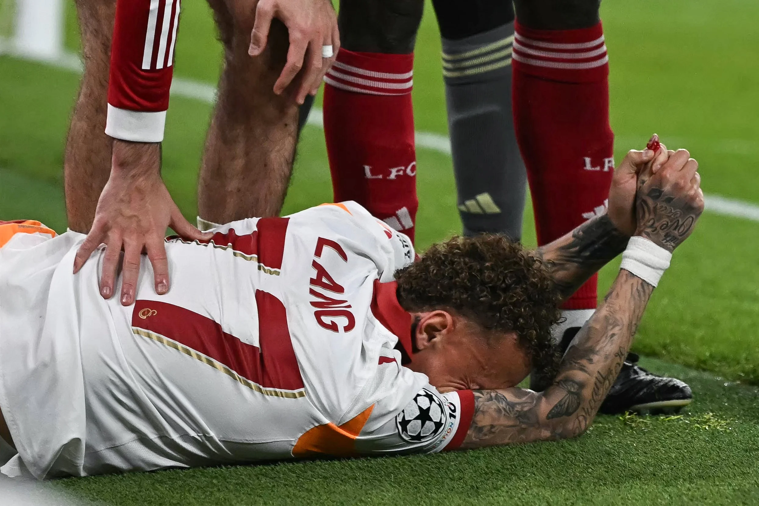 Galatasaray's Dutch forward #77 Noa Lang reacts on the floor after cutting his thumb during the UEFA Champions League, round of 16 second leg football match between Liverpool and Galatasaray at Anfield in Liverpool, north-west England on March 18, 2026. (Photo by Paul ELLIS / AFP via Getty Images)